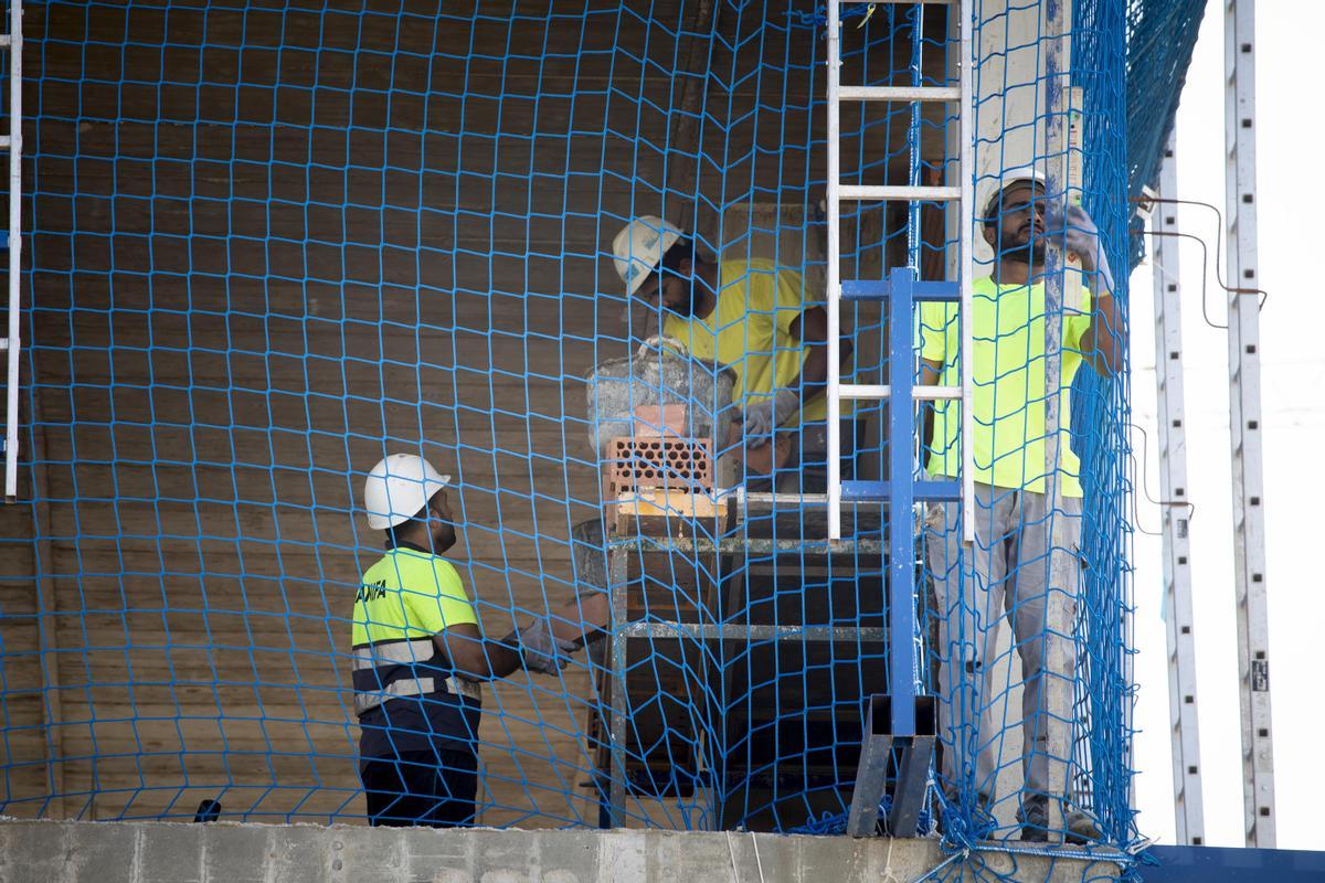 Obreros de la construcción trabajando en un edificio.