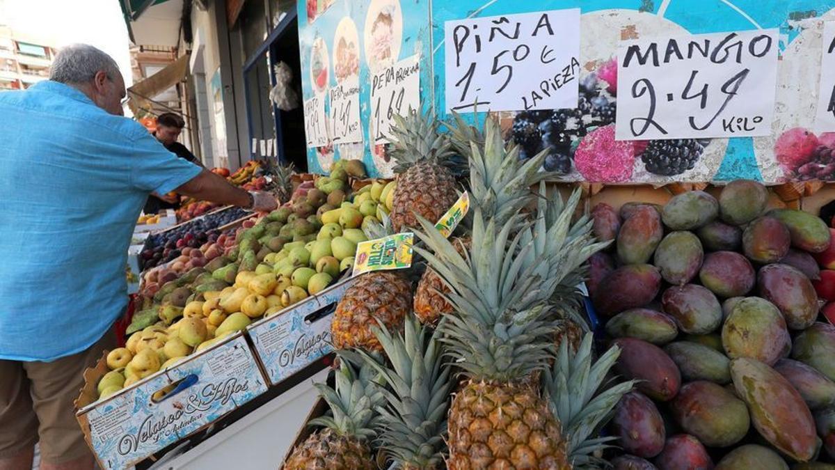 Ciudadanos comprando frutas en un local de barrio en Valencia.