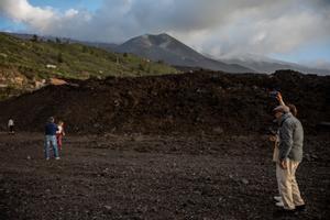 Las coladas del volcán Cumbre Vieja (La Palma) atraen al turismo Turistas fotografían la colada del volcán de Cumbre Vieja.