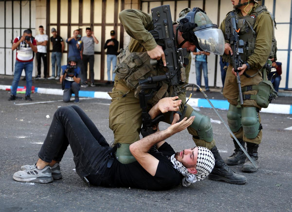 Hebrón, Cisjordania, el 20 de octubre de 2022.- Soldados israelíes arrestan a un hombre palestino durante enfrentamientos tras una protesta en el centro de la ciudad de Hebrón, Cisjordania.