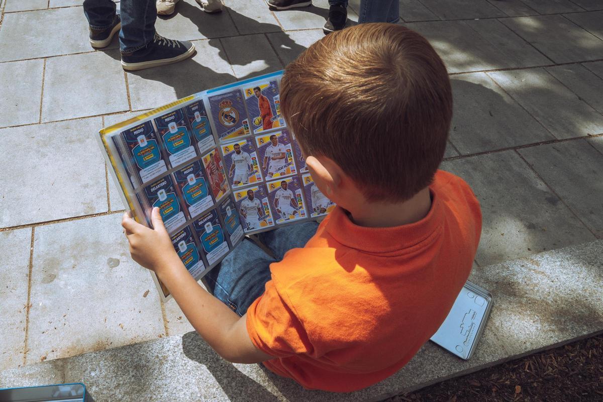 Un niño mira su álbum de cromos. Un niño mira su álbum de cromos.