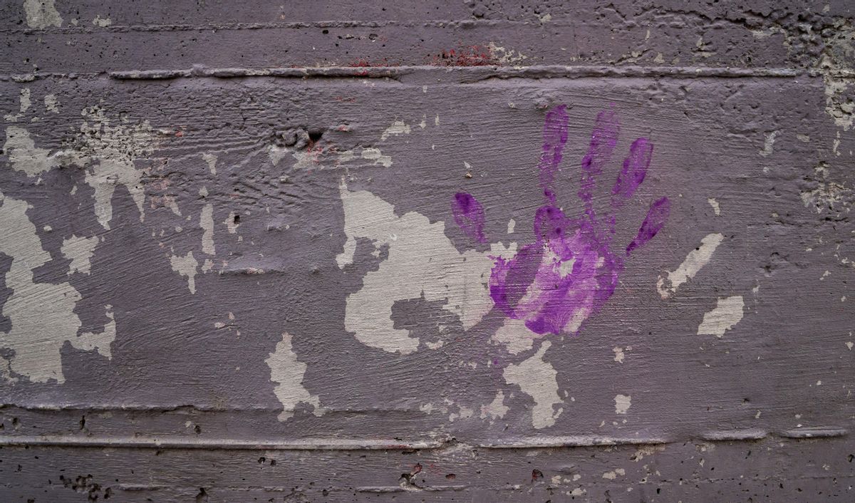 Una mano morada sobre una pared como forma de reivindicar el feminismo en los barrios. Una mano morada sobre una pared como forma de reivindicar el feminismo en los barrios.