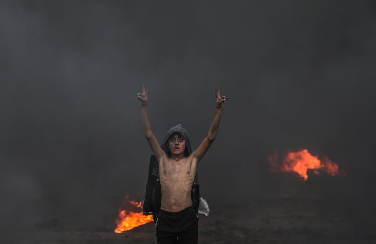 GAZA (GAZA Y CISJORDANIA), 26/10/2018.- Un niño palestino protesta durante los altercados cerca de la frontera entre Israel y Gaza, hoy, 26 de octubre de 2018. Cuatro palestinos murieron hoy por disparos del Ejército israelí y al menos 85 resultaron heridos en las protestas en la Franja de Gaza junto a la frontera con Israel, informaron fuentes médicas palestinas. 