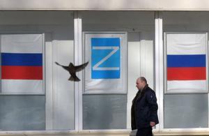 22 de marzo de 2022. Un hombre camina frente a un edificio decorado con la letra Z en Kronstadt (Rusia). 