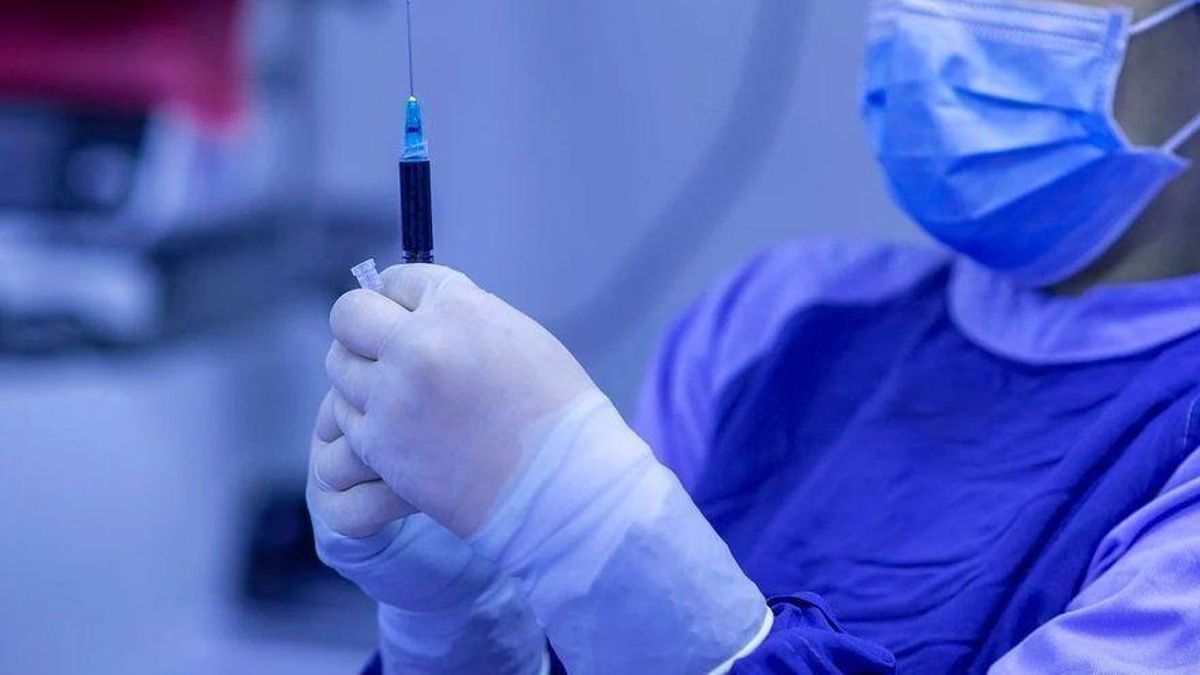 Una sanitaria con una vacuna. Una sanitaria con una vacuna.