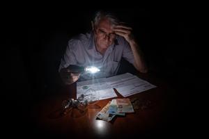 Un hombre de 60 años mira con preocupación la factura de la luz