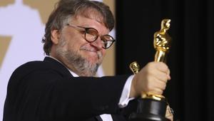 Guillermo del Toro posa con dos estatuillas de los Oscars.