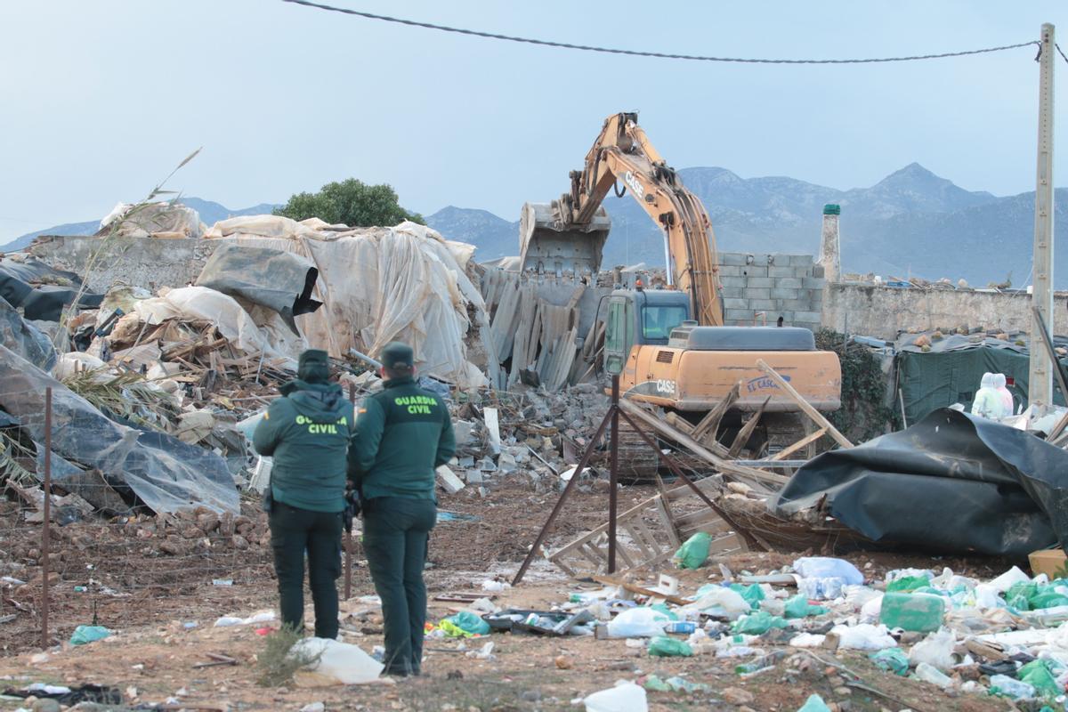 Dos agentes de Guardia Civil asisten al desalojo y derribo del asentamiento chabolista de El Walili en Níjar (Almería).