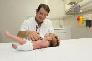 Un pediatra atiende a un bebé.