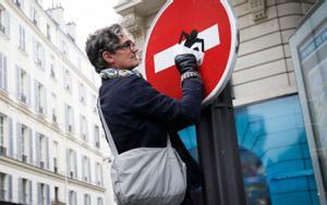 Clet Abraham, colocando uno de sus diseños en una señal en el centro de París. 