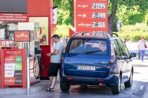 Un hombre echa gasolina en una estación de servicio, el primer día de la primera operación salida del verano de 2022, a 1 de julio de 2022, en Madrid.