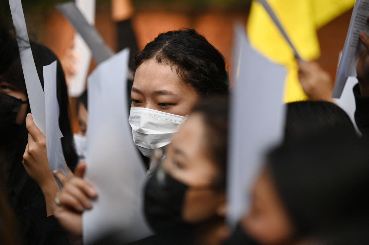 Nueva Delhi (India), 2 de diciembre de 2022.- Activistas del Congreso de Juventud Tibetano portan carteles blancos para solidarizarse con las protestas en China contra las restricciones por el Covid cero