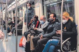 Viajeros con mascarilla en el metro.