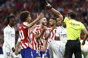 Los jugadores del Atlético de Madrid rodean al colegiado Munuera Montero tras la expulsión de Mario Hermoso en el derbi contra el Real Madrid.