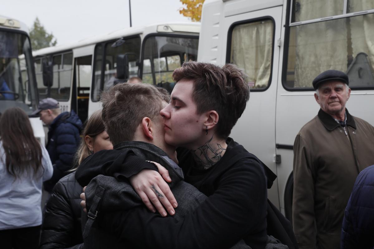 Hombres rusos movilizados se despiden de sus familiares en una oficina de reclutamiento. 