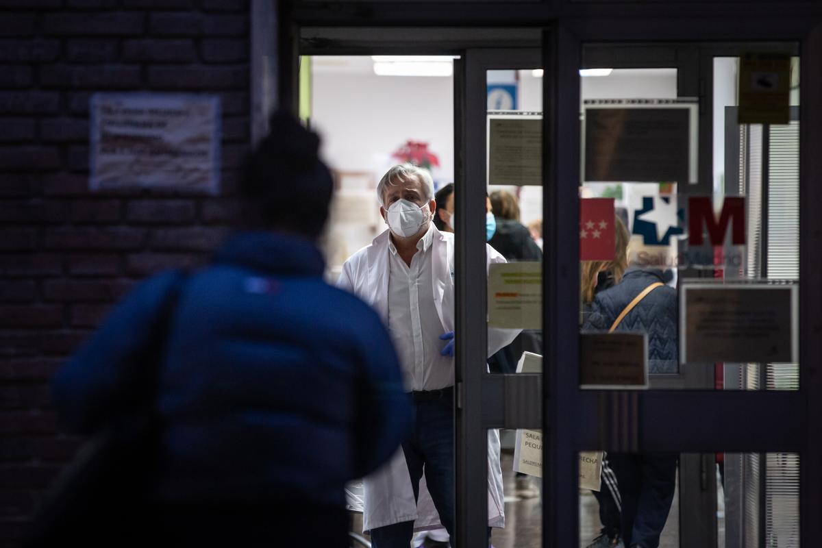 Un médico atiende a una paciente que espera fuera de un centro de salud en Madrid.