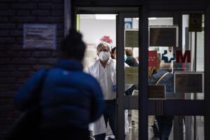 Un médico atiende a una paciente que espera fuera de un centro de salud en Madrid.
