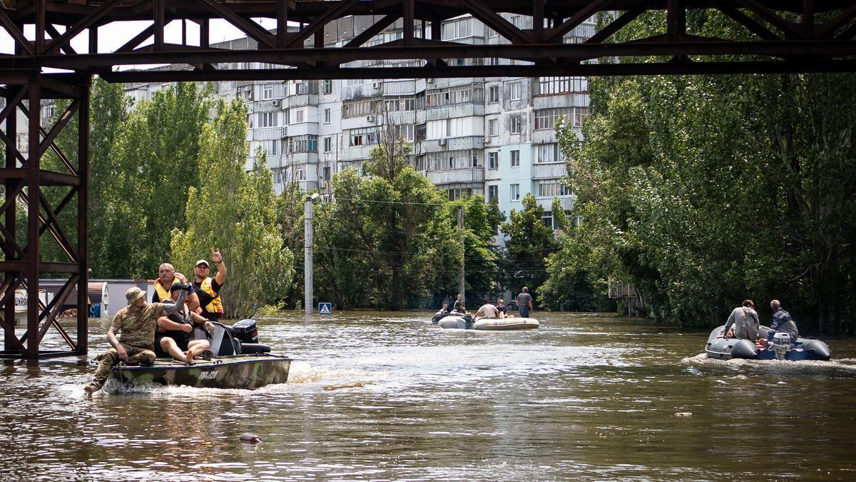 Ciudadanos de Jersón se mueven en lanchas por las calles inundadas por la destrucción de la presa de Novo Kajovka.