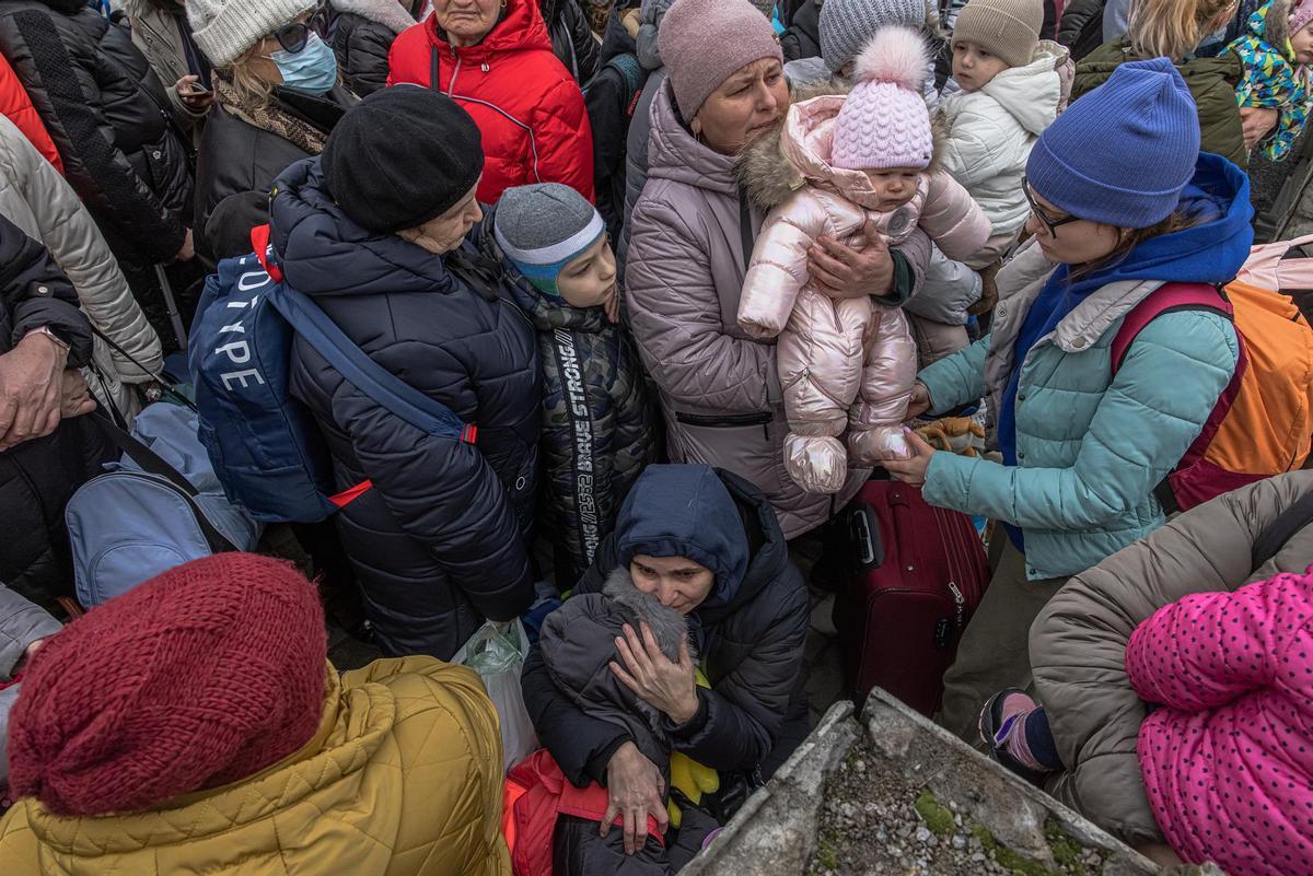 Una madre sostiene a su hijo mientras la gente espera un tren de evacuación a la ciudad de Kiev, en la estación de tren de Irpin. 