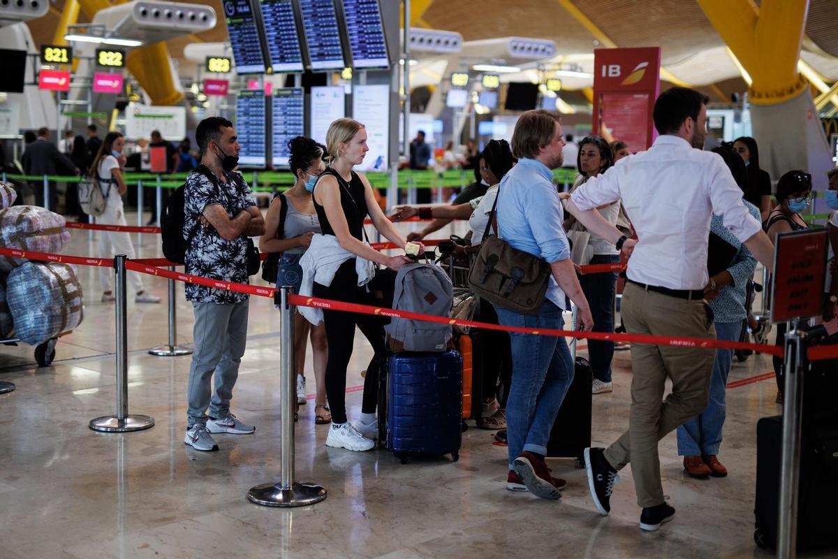 Varias personas con maletas hacen cola en la T4 del aeropuerto Adolfo Suárez Madrid-Barajas.