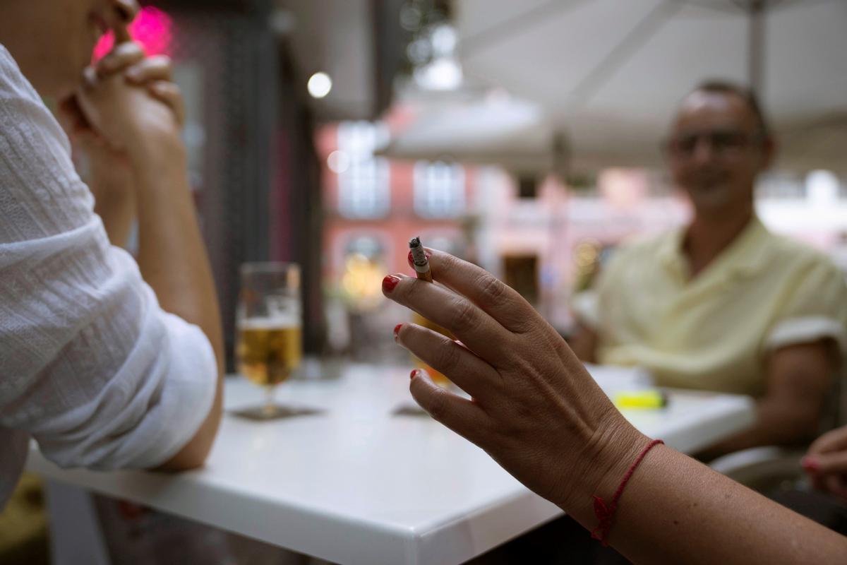 Una mujer sostiene un cigarrillo en la terraza de en un bar en Santa Cruz de Tenerife.