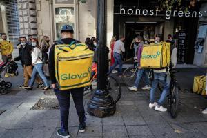 Repartidores de Glovo esperan delante de un restaurante en Barcelona