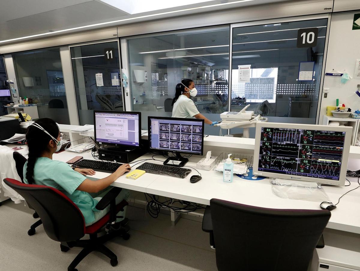 Una enfermera de la UCI del Complejo Hospitalario de Navarra controla a través de un monitor a los pacientes ingresados en la Unidad de Cuidados Intensivos. 
