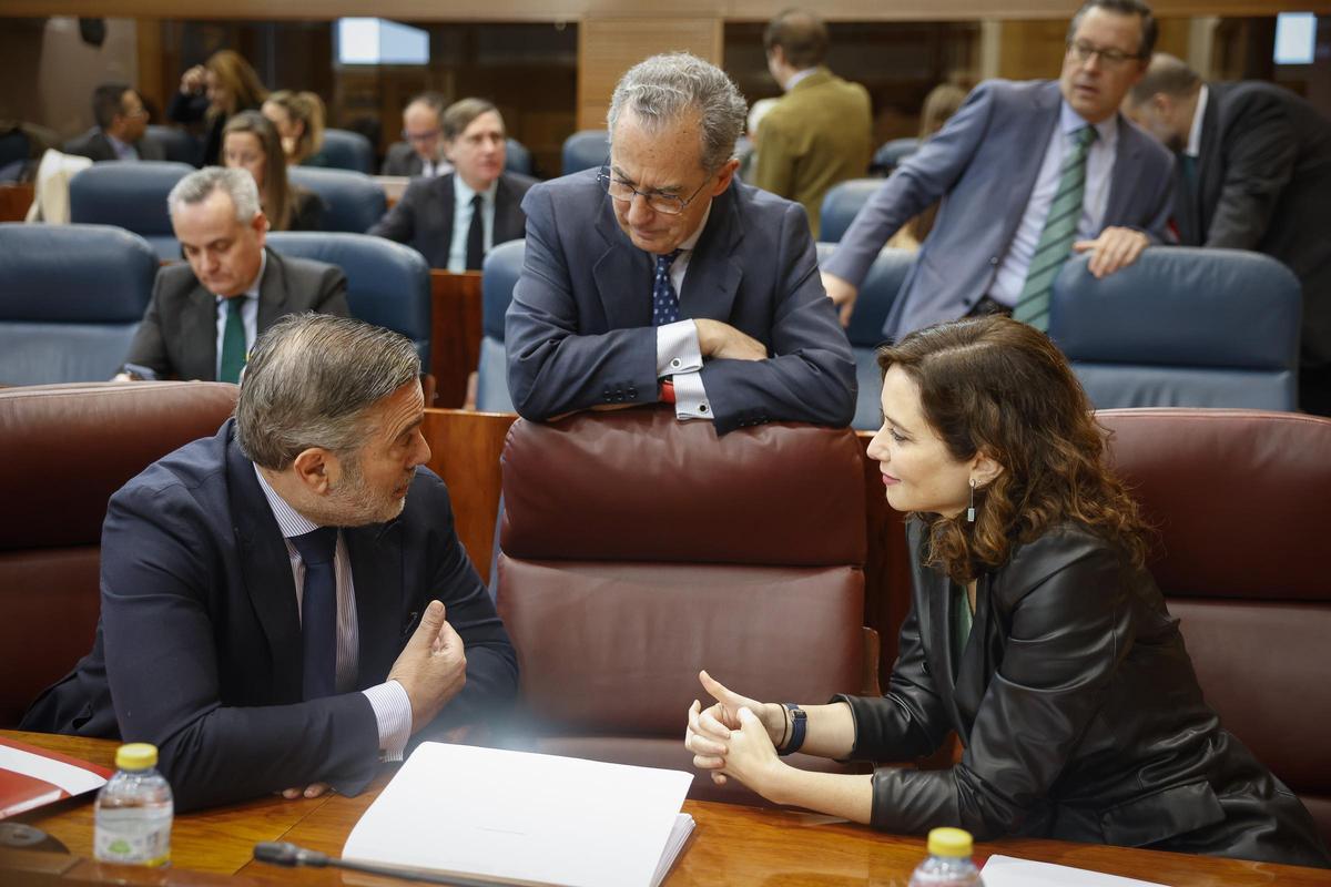 Isabel Díaz Ayuso habla con Enrique López en la Asamblea de Madrid ante la mirada de Enrique Ossorio. Isabel Díaz Ayuso habla con Enrique López en la Asamblea de Madrid ante la mirada de Enrique Ossorio.