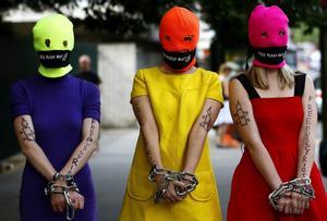  Un grupo de simpatizantes de las Pussy Riot con pasamontañas fluorescentes, pañuelos en la boca y las manos encadenadas.
