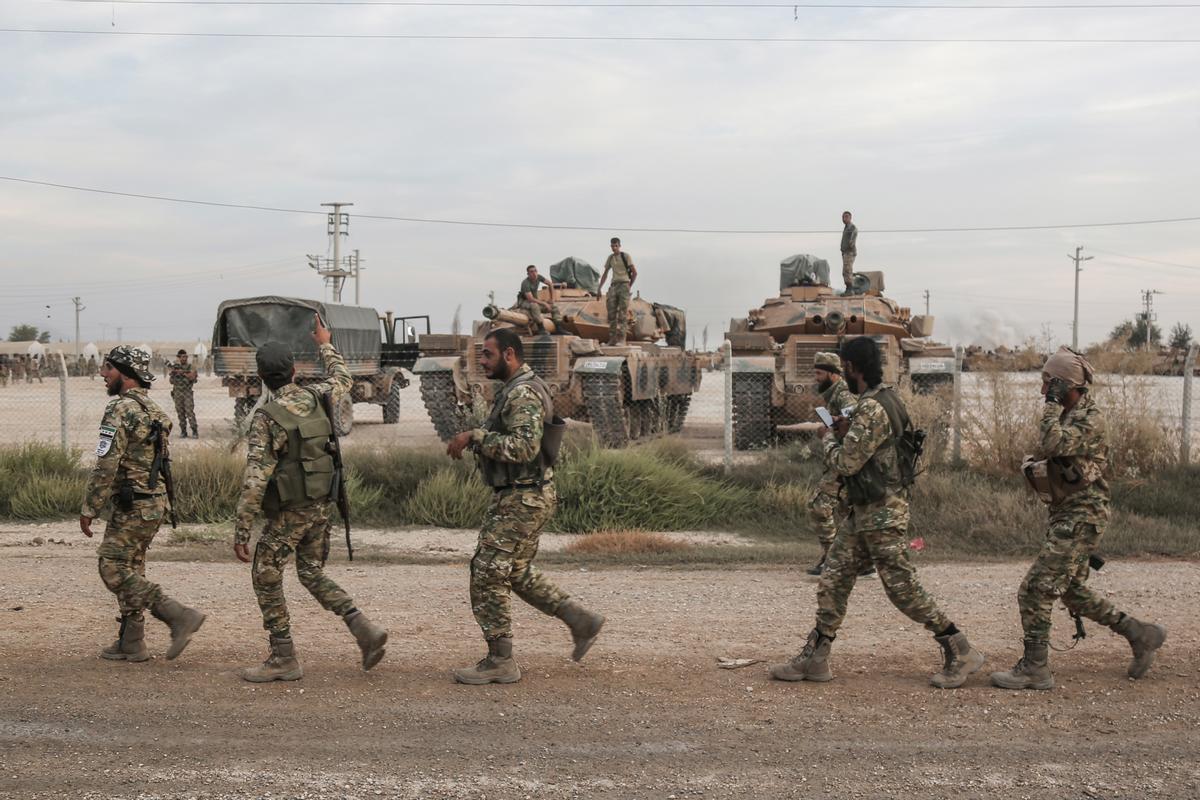 Soldados y vehículos militares de Turquía en una zona de estacionamiento para el Ejército y los rebeldes sirios a los que apoya Ankara.