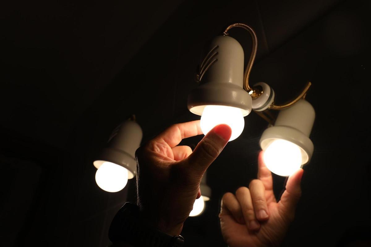 Una persona cambia la bombilla de una lámpara.