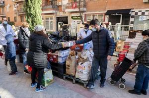 Personas en riesgo de exclusión acuden a recoger alimentos de la Fundación Madrina, en la plaza de San Amaro, a 7 de enero, en Madrid.