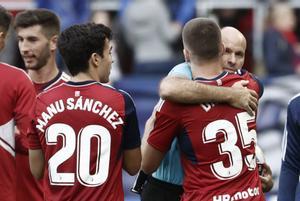 Los jugadores de Osasuna abrazan a Mateul Lahoz tras la disputa del partido contra Osasuna.