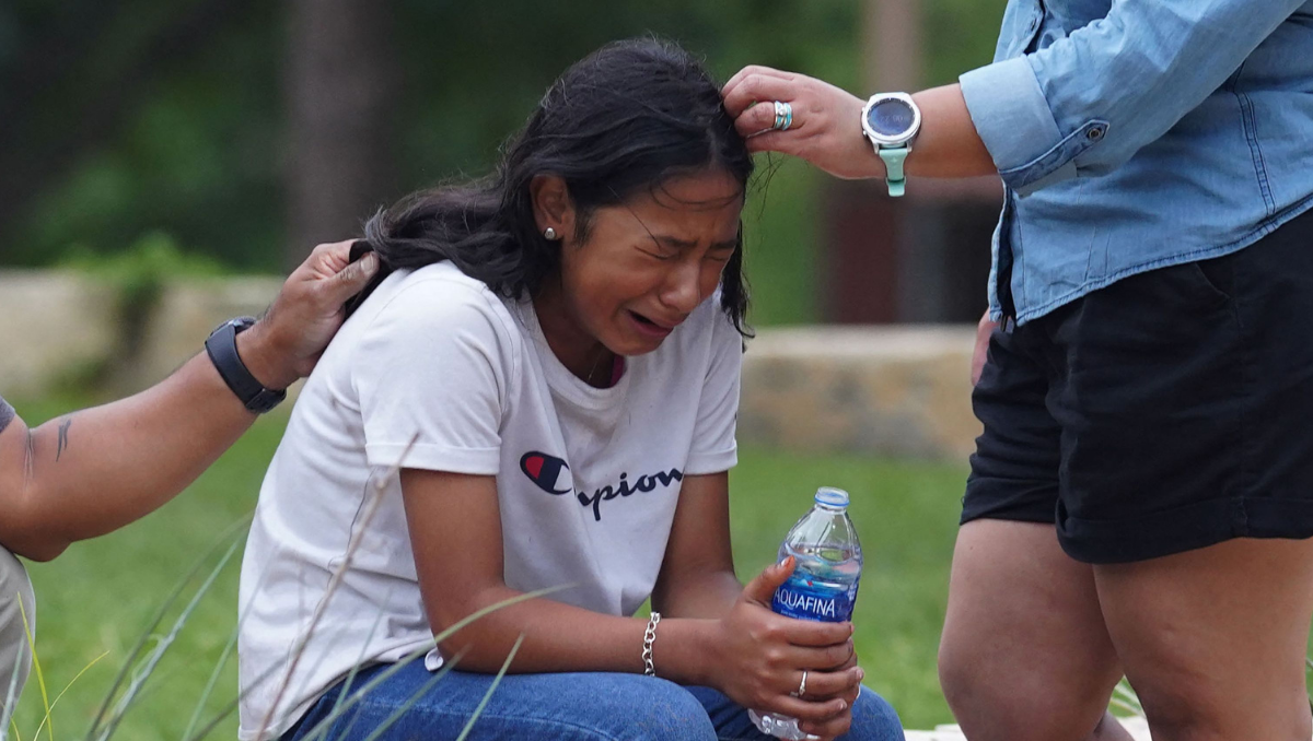 Dos adultos intentan consolar a una niña que llora en las afueras de un centro cívico en Uvalde, Texas, tras la masacre en una escuela de la localidad.