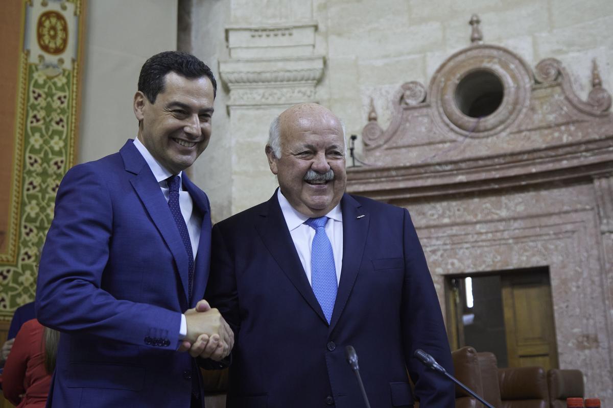El presidente de la Junta, Juan Manuel Moreno, saluda a Jesús Aguirre, primer presidente del PP del Parlamento de Andalucía.