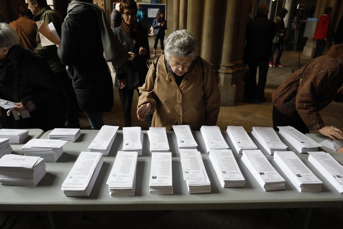Una mujer, en Barcelona, observa las papeletas de voto, en las últimas elecciones generales.  