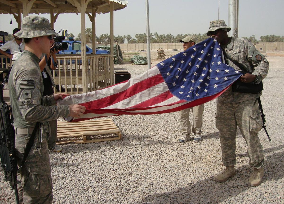 Soldados de EEUU despliegan una bandera en la base de Hila, al sur de Bagdad.