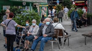Un grupo de personas en una plaza de Barcelona con mascarillas. 