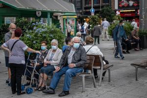 Un grupo de personas en una plaza de Barcelona con mascarillas. 
