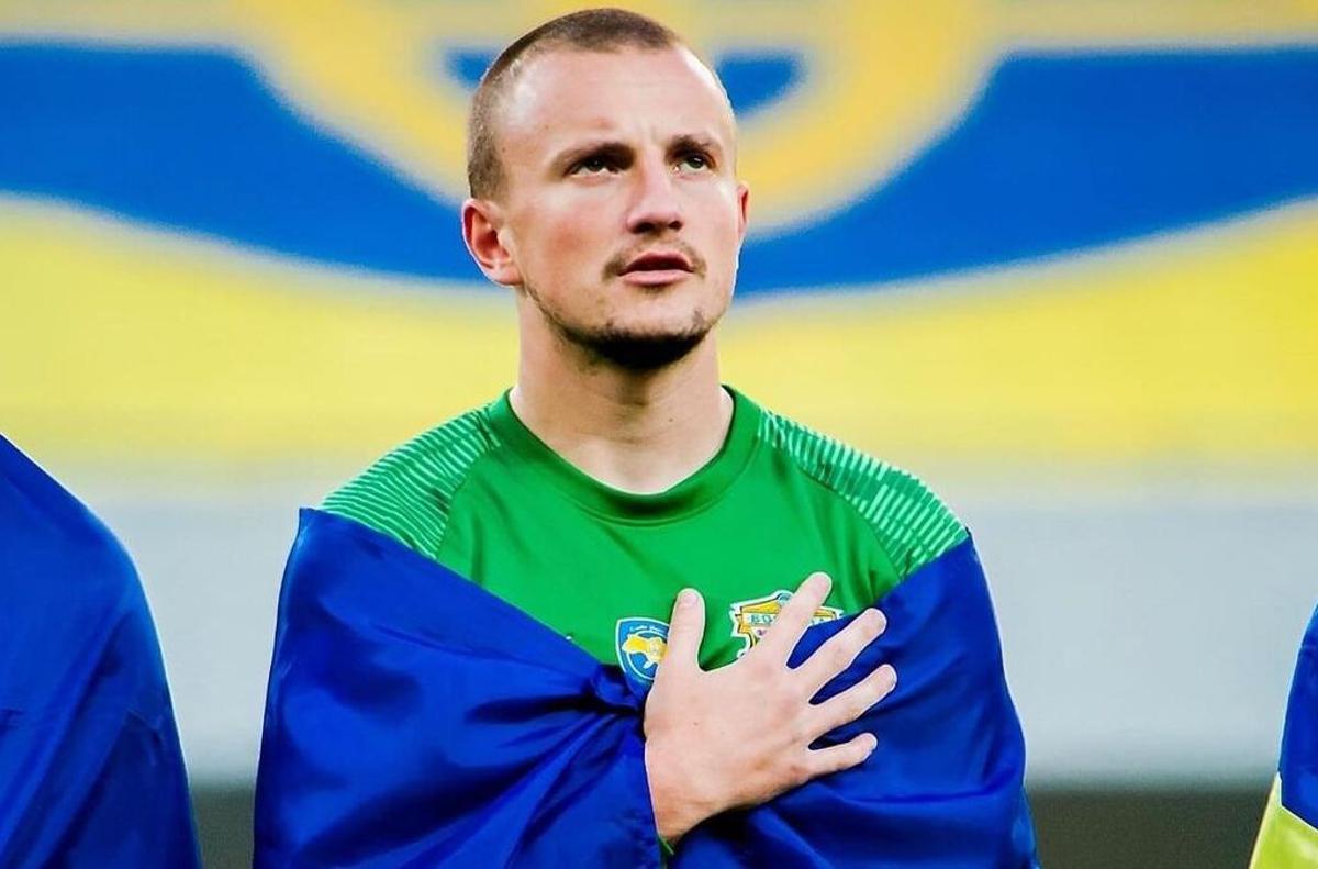 Vasyl Kravets, envuelto en la bandera de Ucrania y cantando el himno en un partido de la liga de su país.