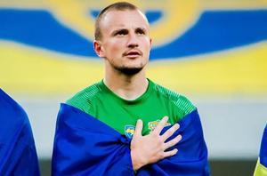 Vasyl Kravets, envuelto en la bandera de Ucrania y cantando el himno en un partido de la liga de su país.