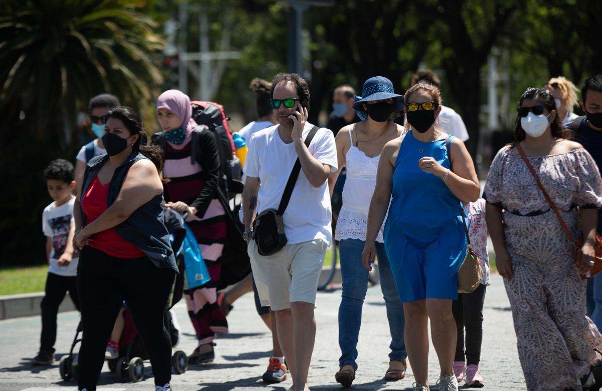 Un grupo de personas pasea por Sevilla, algunos con y otros sin mascarillas.