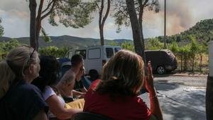 Varias personas miran el fuego desde el camping de Altura.