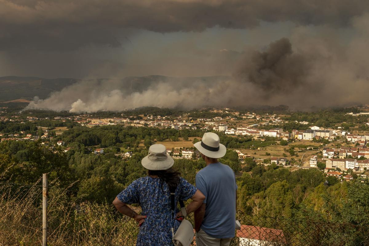Dos personas observan el incendio de Verín