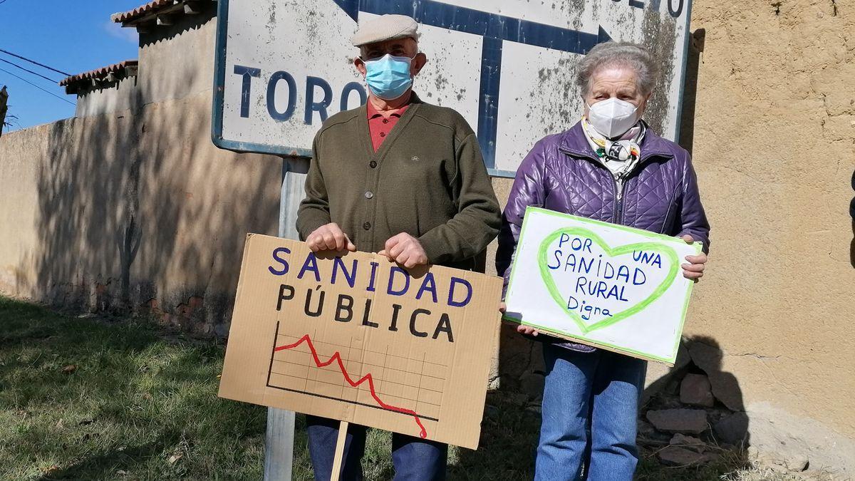 Dos vecinos de Pozoantiguo muestran pancartas de protesta