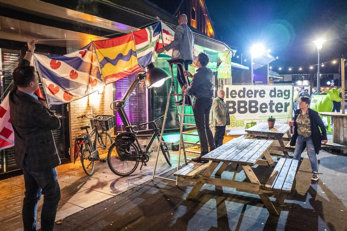 Miembros del partido rural holandés BBB cuelgan banderas para festejar su victoria en los comicios, este miércoles. 