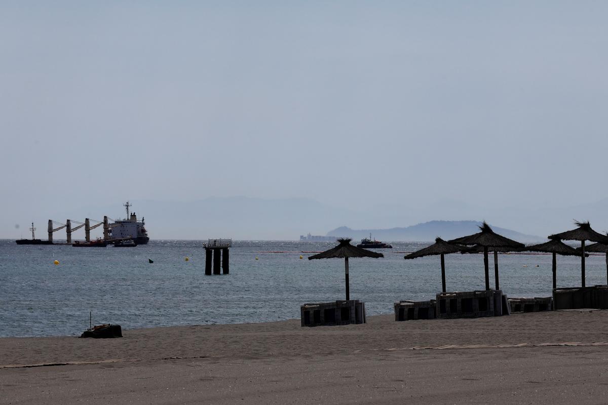 En la imagen de archivo, vista de la playa de Poniente de la Línea de la Concepción, y el OS35, buque varado al Este de Gibraltar tras la colisión que sufrió.