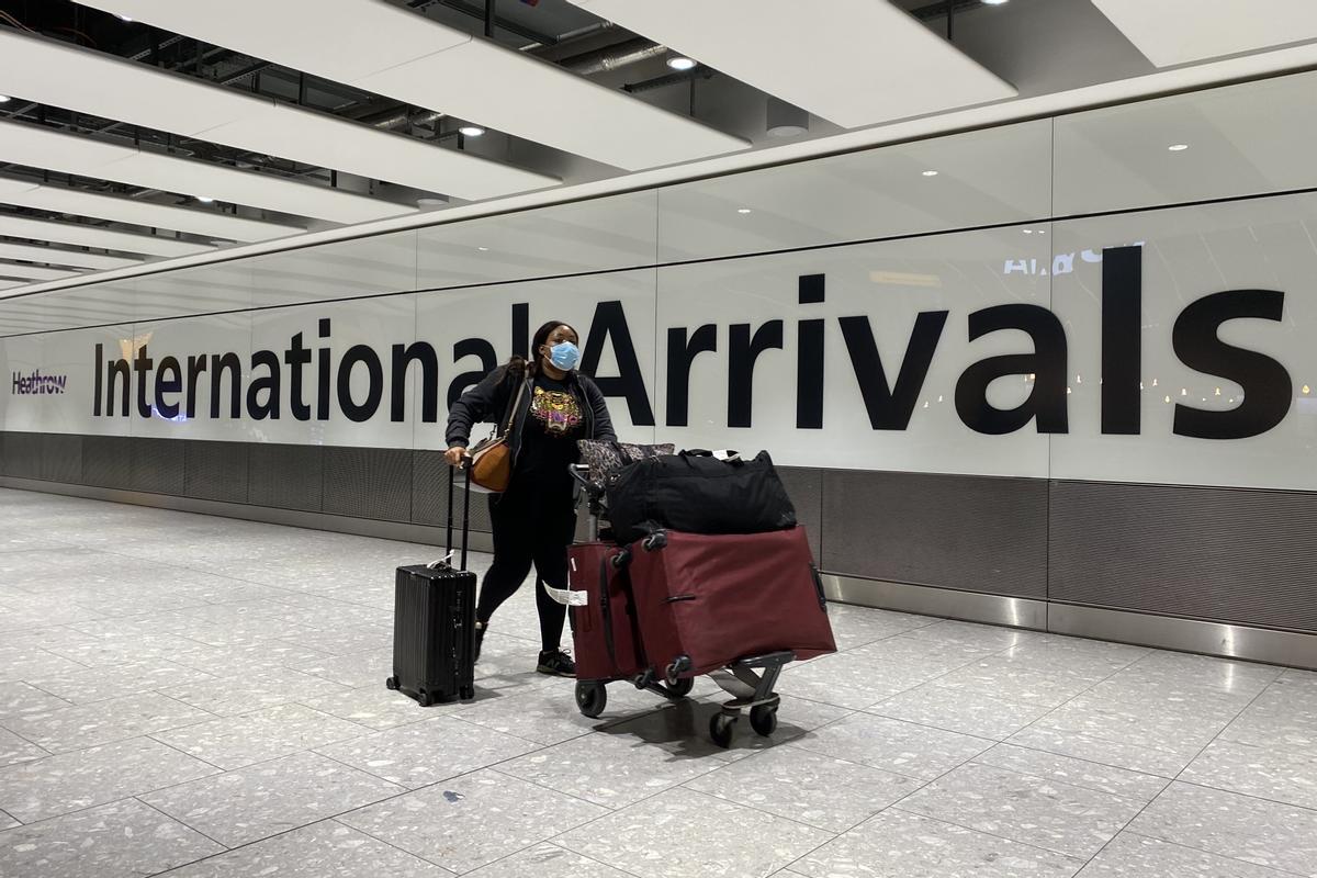 Una pasajera empuja su maleta en un aeropuerto Una pasajera empuja su maleta en un aeropuerto