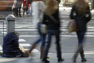 Un mendigo pide limosna al paso de los transeúntes en la Plaza de Cibeles de la capital española, en una imagen de archivo. EFE/Javier Lizón