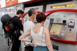 Varios viajeros gestionan la compra de sus abonos en máquinas expendedoras de una estación de Cercanías de Madrid. EFE/Mariscal